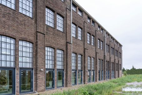 Bâtiment en brique avec des grandes fenêtres types ateliers industriels